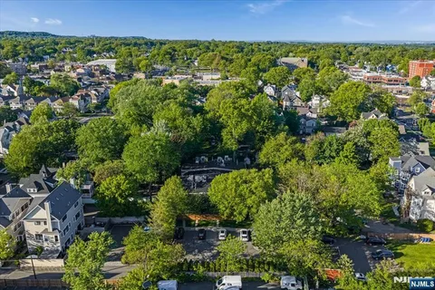 an aerial view of residential house with outdoor space and trees all around