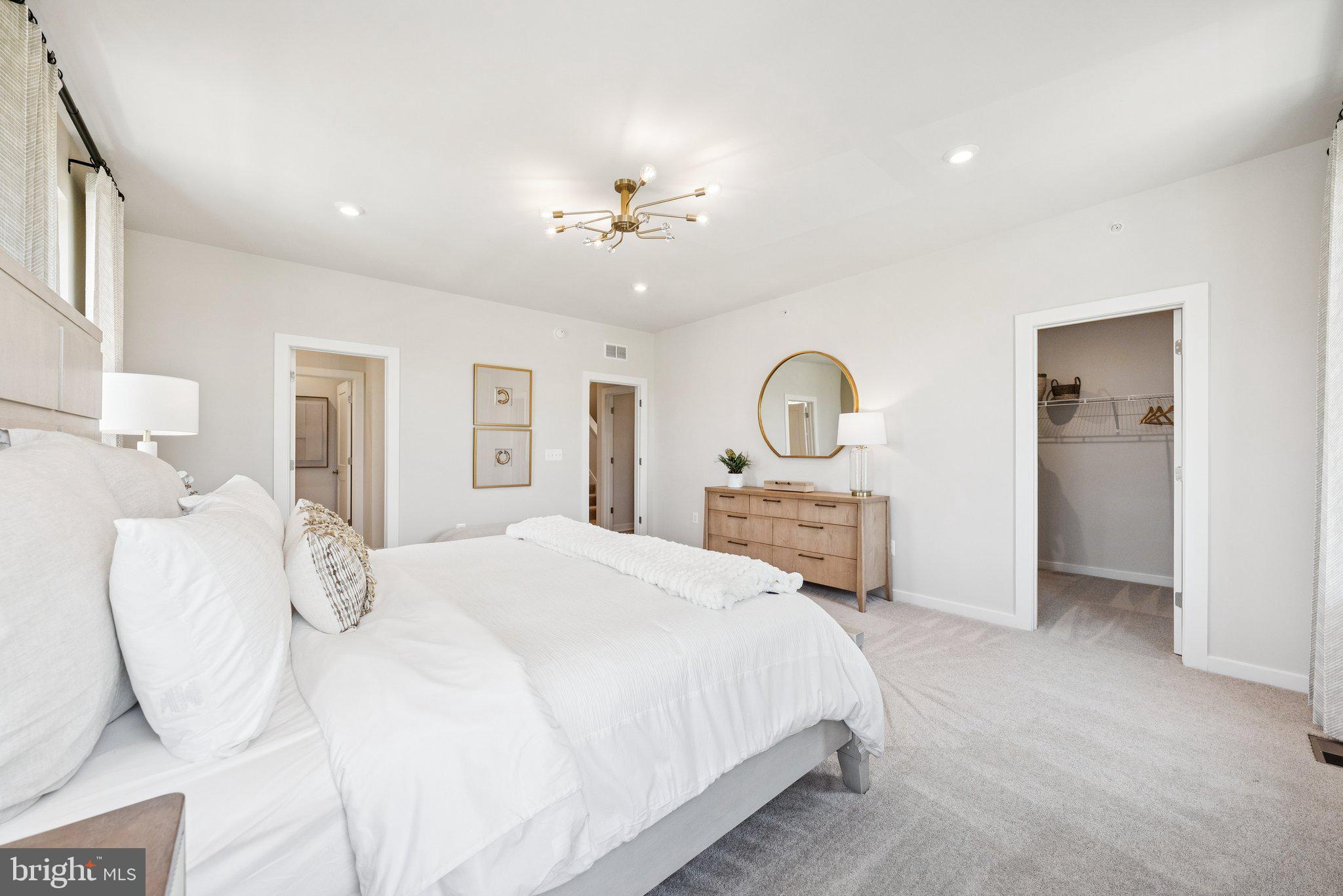 13717 Cobble Loop Woodbridge, VA 22193 - Photo 17 of 34 a spacious bedroom with a bed and a chandelier