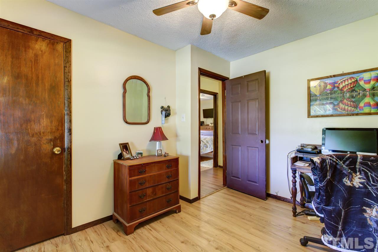 1481 Phillips Road Dunn, NC 28334 - Photo 21 of 30 a bedroom with a bed and a chandelier