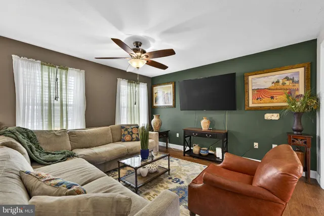 a view of a hallway with wooden floor and a chandelier