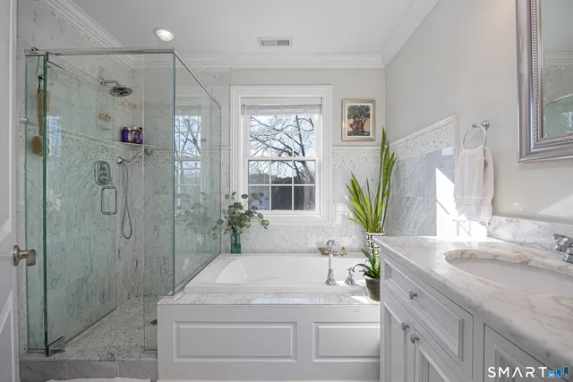 a bathroom with a granite countertop sink a large mirror and a bathtub