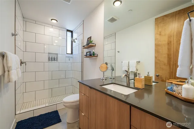 a bathroom with a sink a toilet and shower