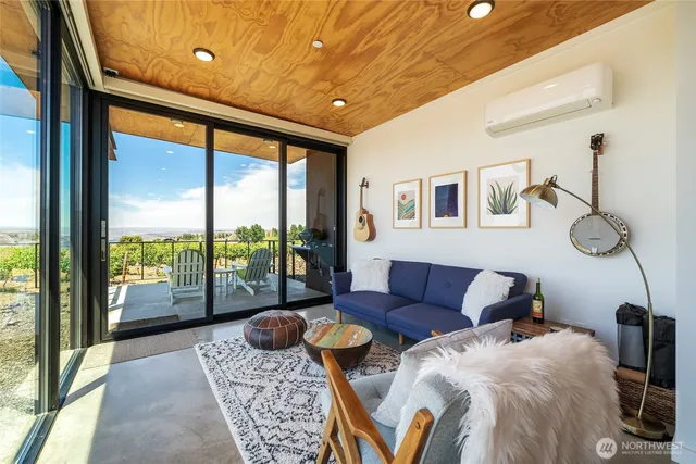 a living room with furniture and a floor to ceiling window