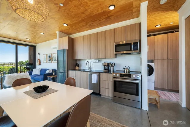 a kitchen with stainless steel appliances a stove a sink a microwave a refrigerator and cabinets