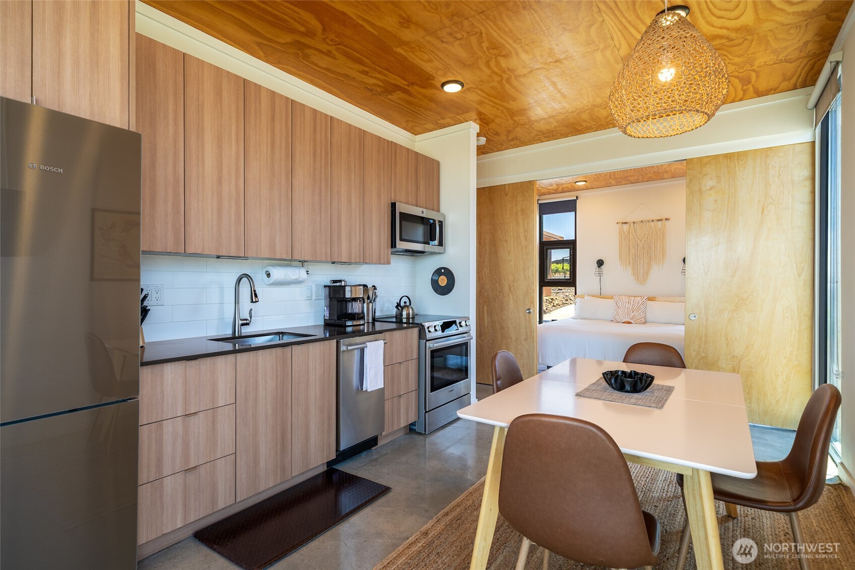 23648 Northwest Cliffe Pointe Road, Unit 10C Quincy, WA 98848 - Photo 10 of 26 a kitchen with stainless steel appliances kitchen island a table chairs in it and wooden floors