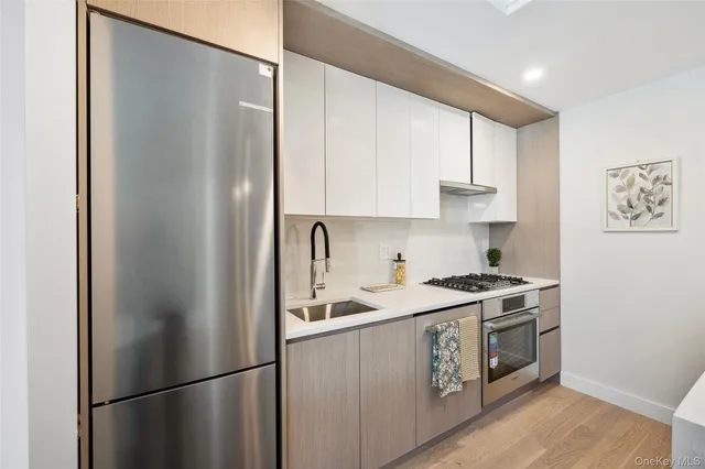 a kitchen with a refrigerator sink stove and cabinets