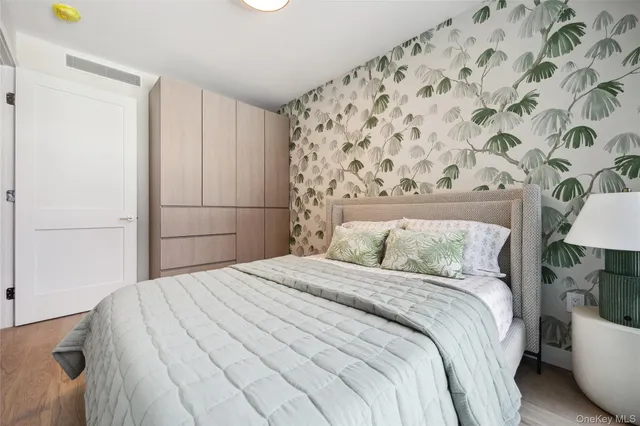 a bedroom with a bed and a lamp on the dresser