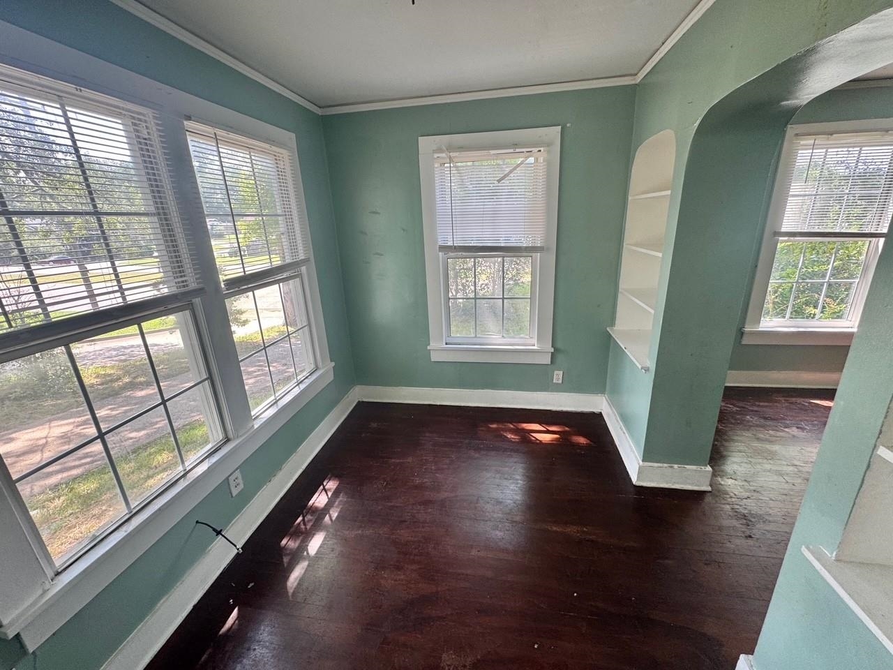4564 Stage Road Memphis, TN 38128 - Photo 4 of 15 Unfurnished room with healthy amount of natural light, crown molding, dark wood finished floors, and arched walkways