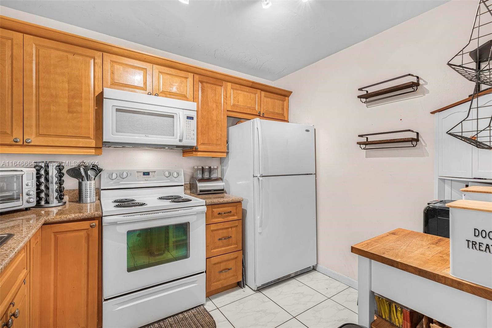 11249 Southwest 88th Street, Unit 203G Miami, FL 33173 - Photo 12 of 37 a kitchen with a refrigerator stove and microwave