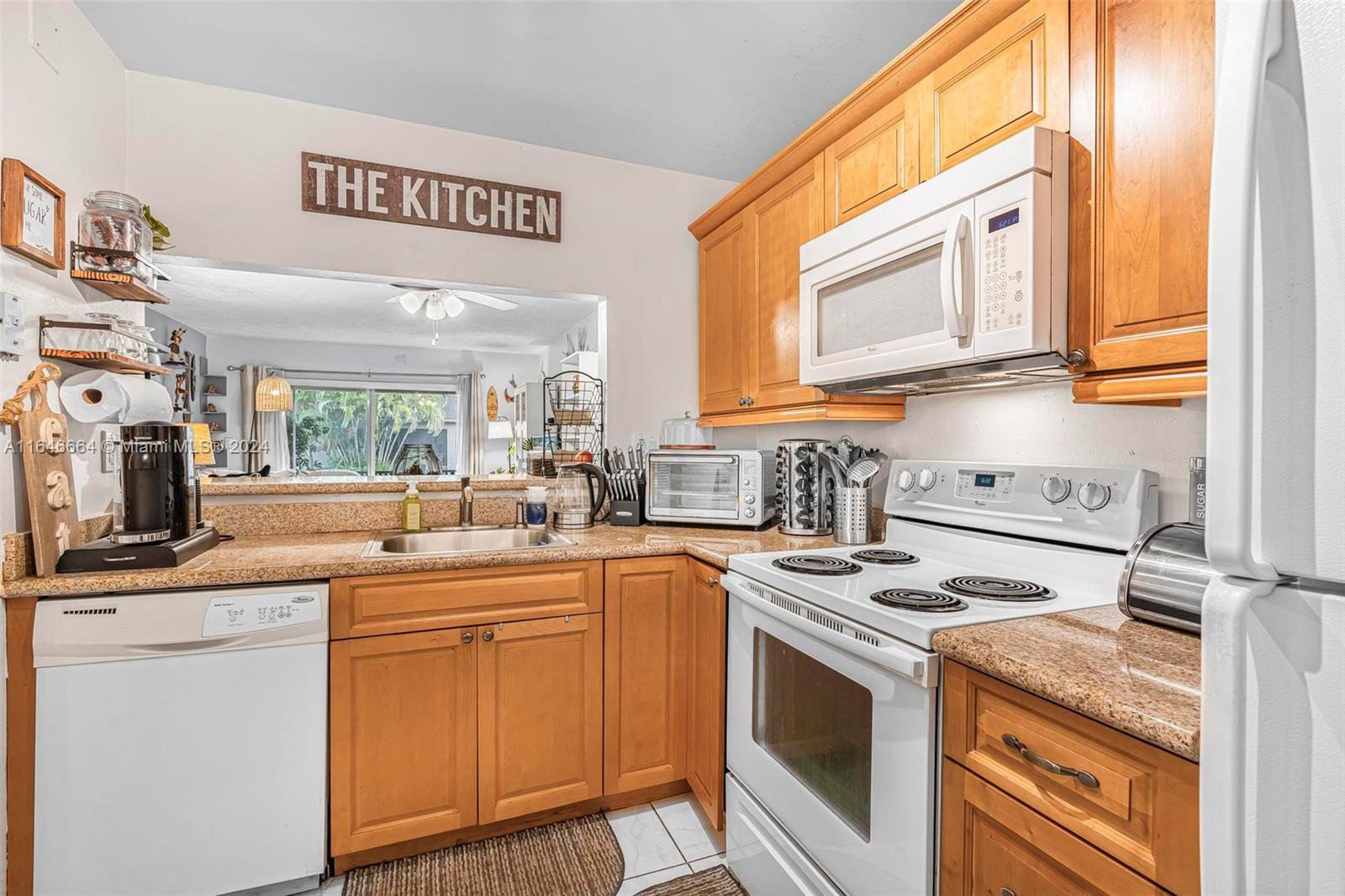 11249 Southwest 88th Street, Unit 203G Miami, FL 33173 - Photo 13 of 37 a kitchen with stainless steel appliances granite countertop a stove a sink and a microwave