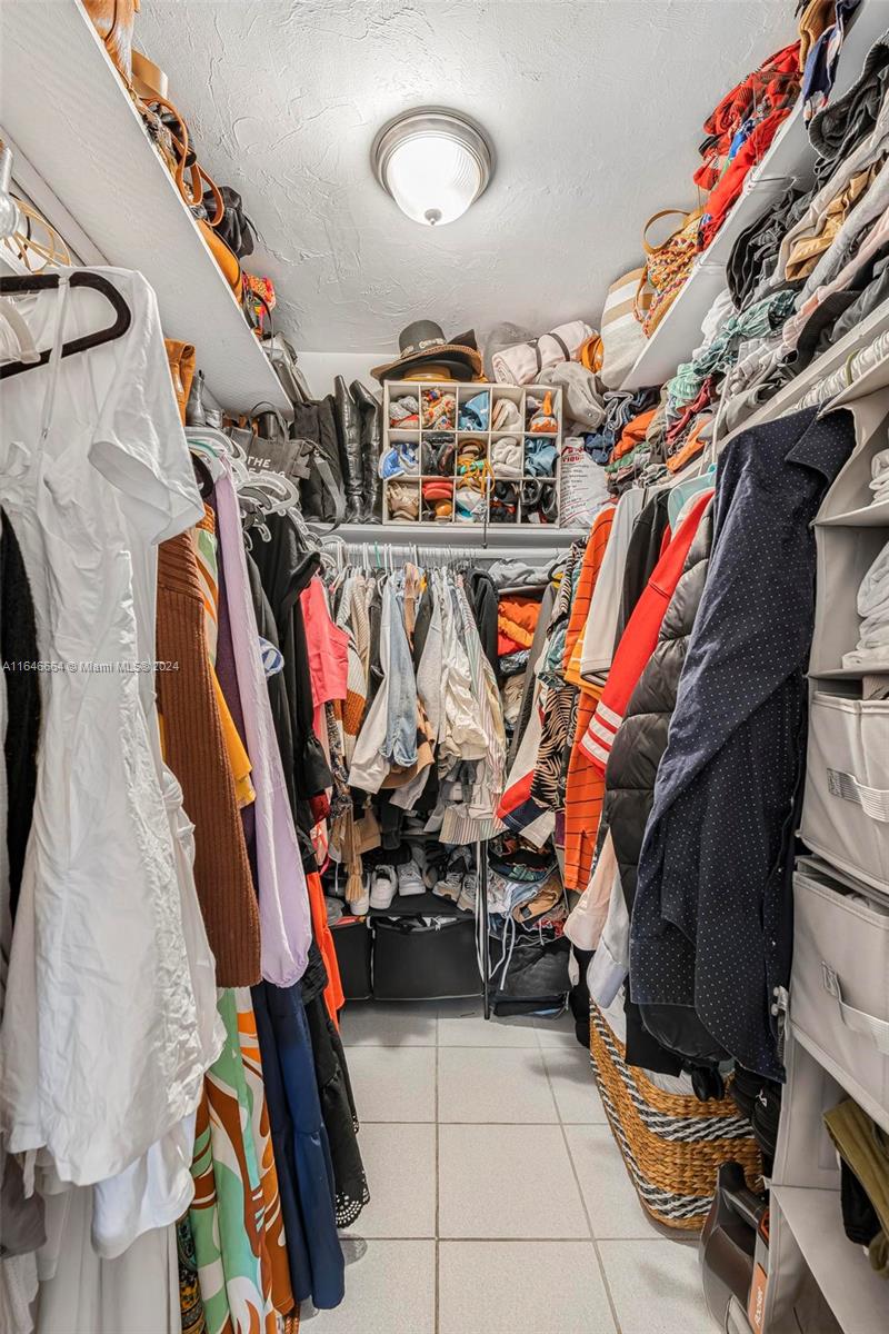11249 Southwest 88th Street, Unit 203G Miami, FL 33173 - Photo 18 of 37 a view of walk in closet with clothes and shoes