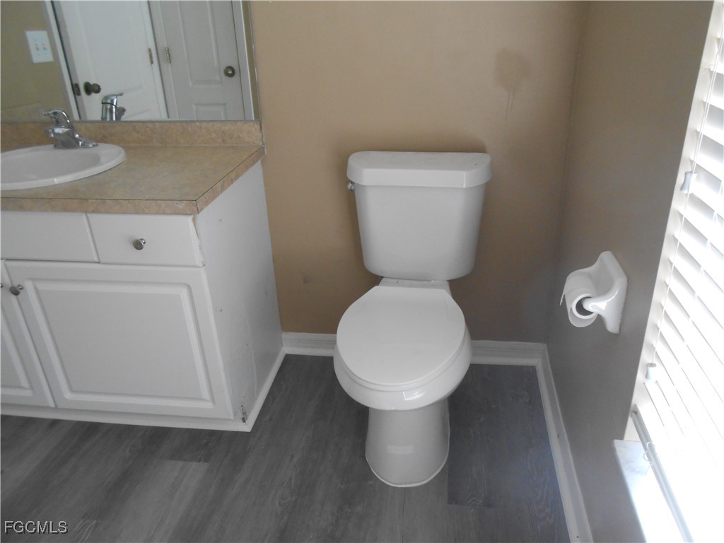 3208 71st Street West Lehigh Acres, FL 33971 - Photo 12 of 24 a white toilet sitting next to a bathroom sink