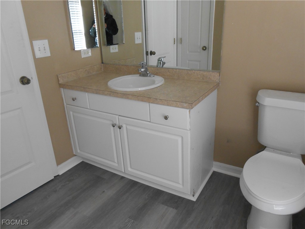 3208 71st Street West Lehigh Acres, FL 33971 - Photo 13 of 24 a bathroom with a toilet sink and mirror