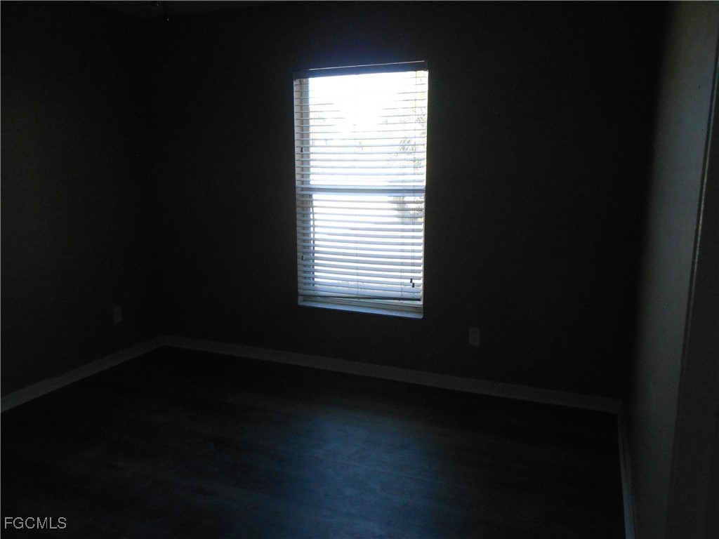 3208 71st Street West Lehigh Acres, FL 33971 - Photo 14 of 24 a view of an empty room with wooden floor and a window