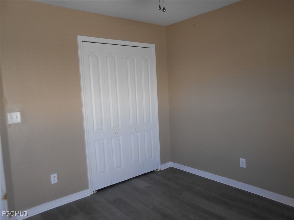 3208 71st Street West Lehigh Acres, FL 33971 - Photo 16 of 24 a view of an empty room with wooden floor