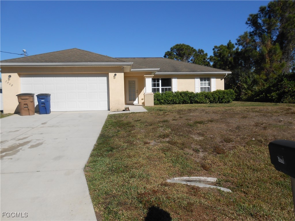 3208 71st Street West Lehigh Acres, FL 33971 - Photo 2 of 24 a front view of a house with a yard