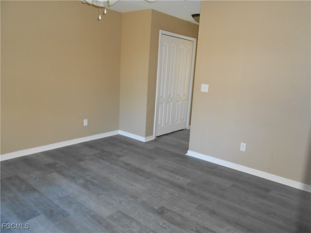 3208 71st Street West Lehigh Acres, FL 33971 - Photo 7 of 24 a view of an empty room with wooden floor