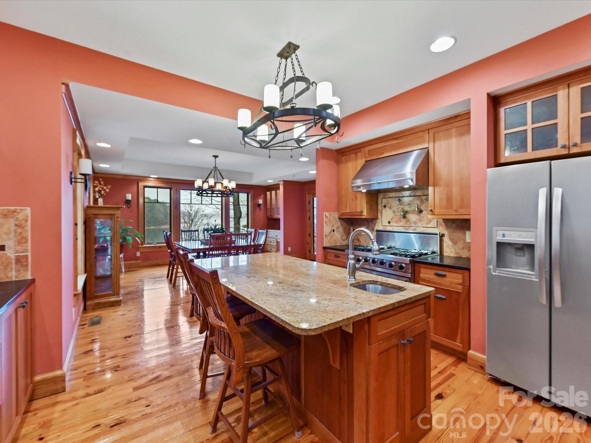 4312 Hazel Street Terrell, NC 28682 - Photo 13 of 45 a kitchen with stainless steel appliances granite countertop a kitchen island a stove a refrigerator a oven a dining table and chairs with wooden floor