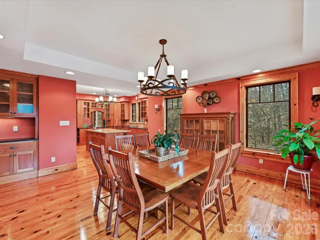 a dining room with furniture a chandelier and wooden floor