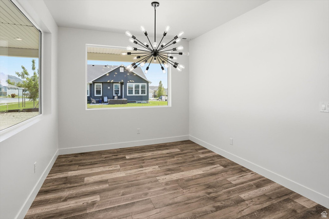 1315 West 3200 South, Unit 17 Perry, UT 84302 - Photo 5 of 58 Spacious room featuring wood-finish flooring, two large windows, a modern chandelier with multiple exposed bulbs, crisp white walls, and white baseboards