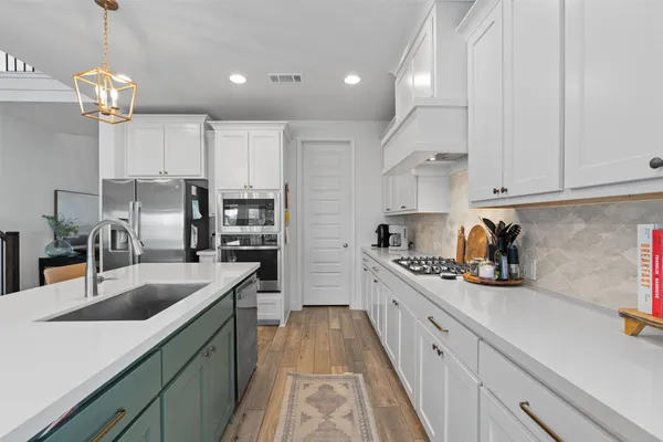 a kitchen with cabinets a sink and appliances