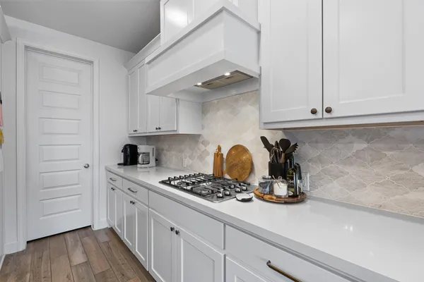 a kitchen with sink a stove and cabinets
