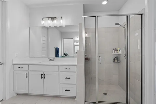 a bathroom with a shower sink and mirror