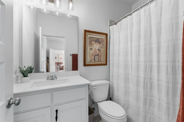 a bathroom with a sink vanity mirror and toilet