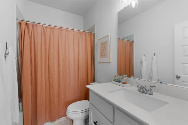 a bathroom with a sink a toilet and shower curtain