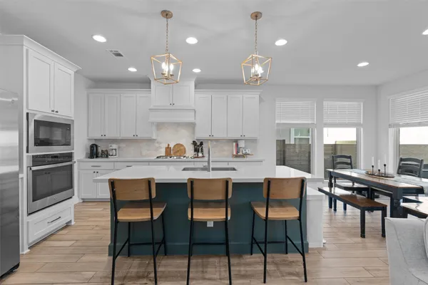 a large kitchen with kitchen island a dining table and chairs