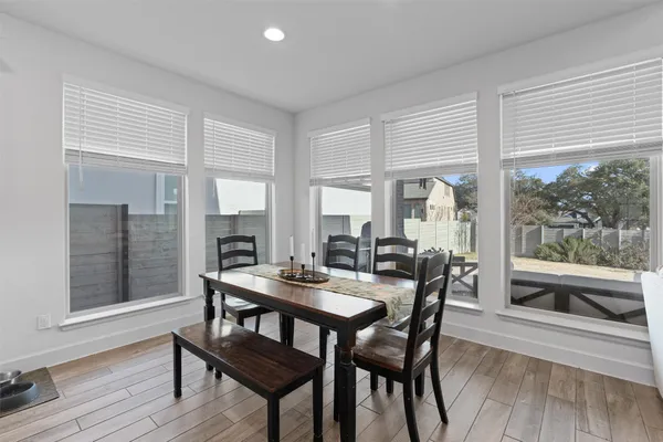 a dining room with furniture large windows and wooden floor