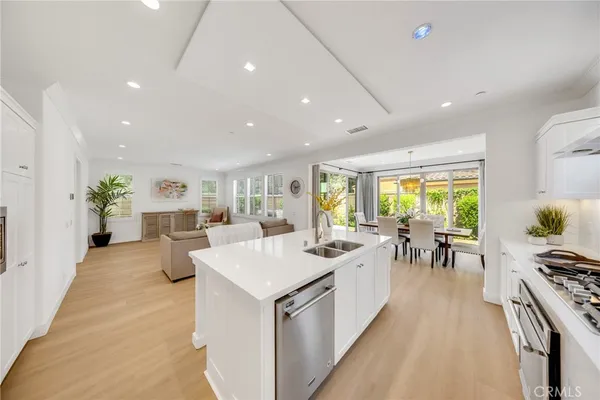 a living room with stainless steel appliances furniture a dining table and chairs