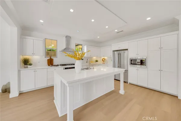 a large white kitchen with cabinets and chairs