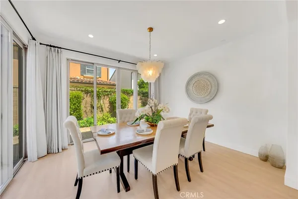 a dining room with furniture a chandelier and a window