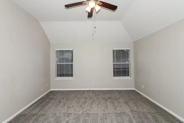 an empty room with chandelier fan