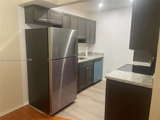 a kitchen with metallic refrigerator freezer and a dishwasher