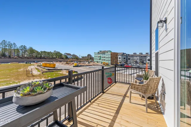 a view of a balcony with wooden chairs and a potted plant