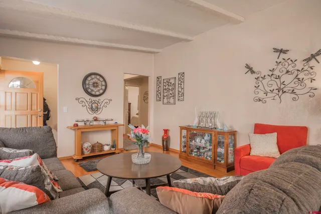 a dining room with furniture and a chandelier fan