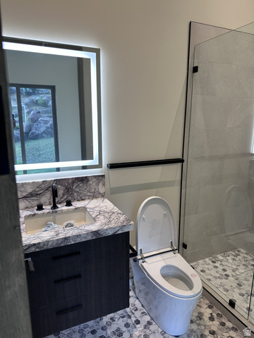 1918 Chimney Rock Road Heber City, UT 84032 - Photo 65 of 74 Modern bathroom featuring a vanity with a marbled countertop, integrated sink, and dark wood-finish cabinetry