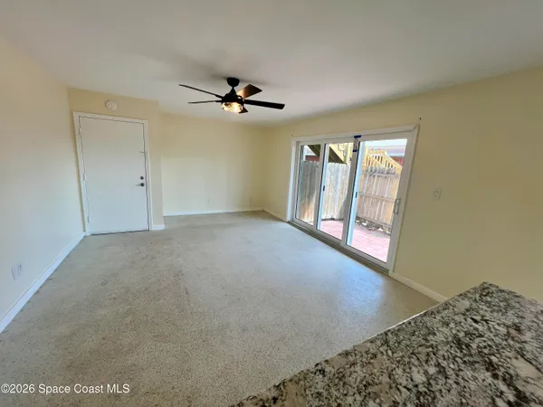 a view of a hallway with wooden floor and a bathroom