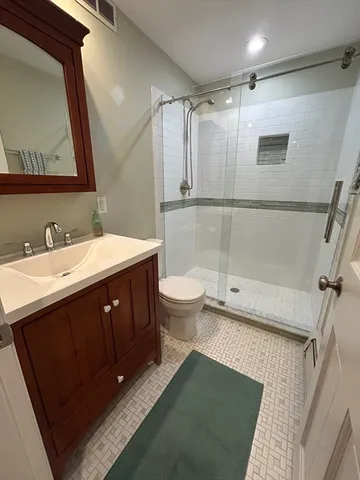 a bathroom with a double vanity sink toilet and shower