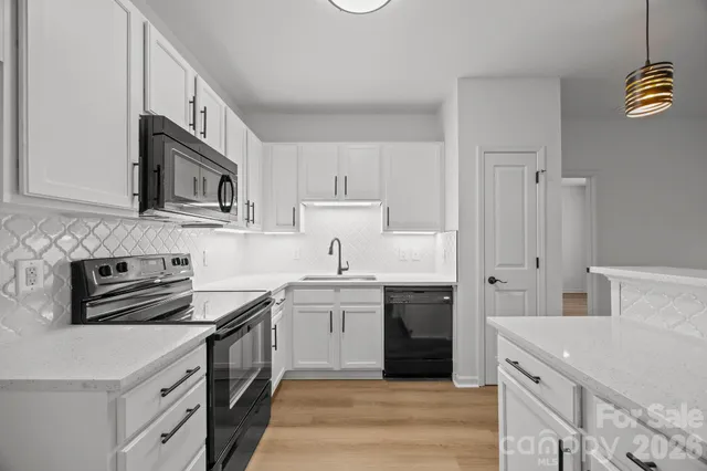 a kitchen with stainless steel appliances granite countertop a sink stove and cabinets