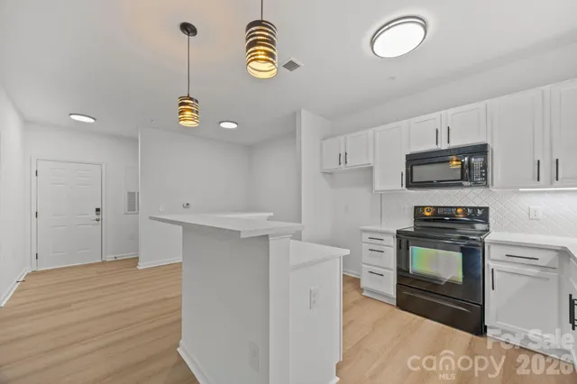 a kitchen with stainless steel appliances granite countertop a sink a stove and a microwave