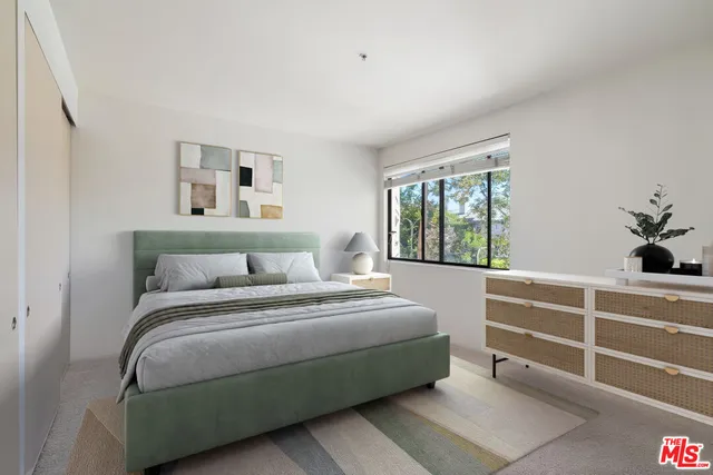 a spacious bedroom with a bed table chair and a two windows