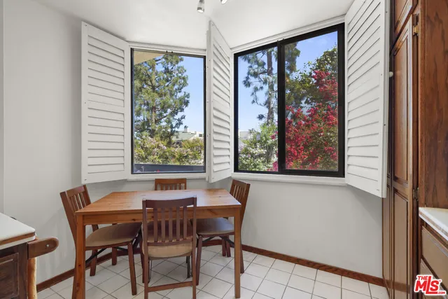 a view of a patio with couches and table and chairs and potted plants