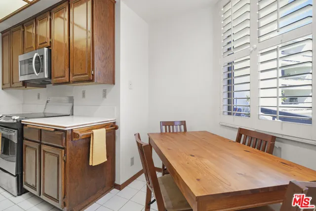 a view of a patio with couches and table and chairs with wooden fence and plants