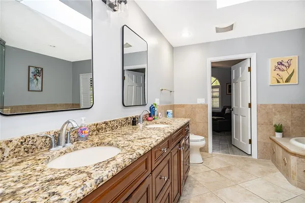 a spacious bathroom with a granite countertop sink and a mirror