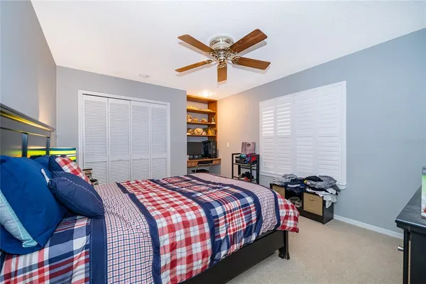 a bedroom with a bed and a ceiling fan
