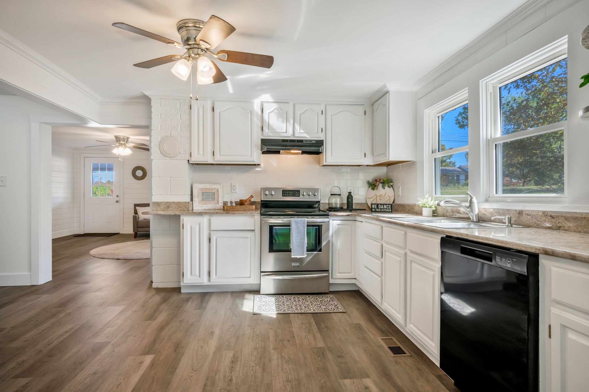 1865 Clydeton Road Waverly, TN 37185 - Photo 10 of 40 a kitchen with stainless steel appliances a stove a sink dishwasher a refrigerator and white cabinets with wooden floor