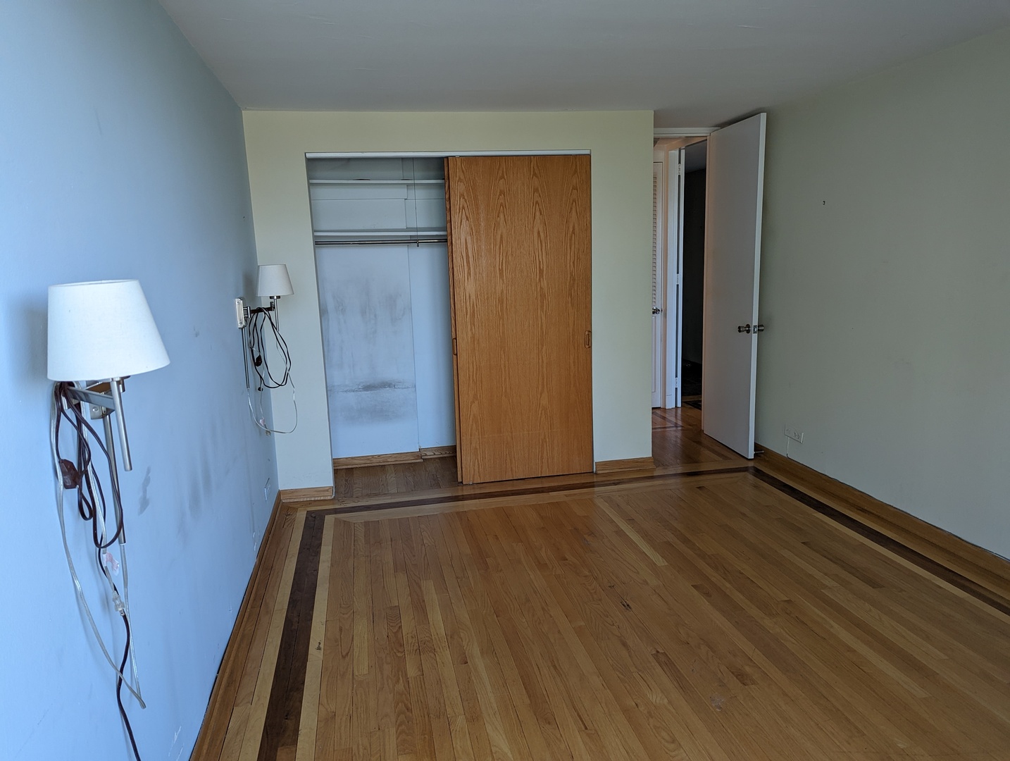720 West Gordon Terrace, Unit 7J Chicago, IL 60613 - Photo 12 of 14 an empty room with wooden floor and a lamp